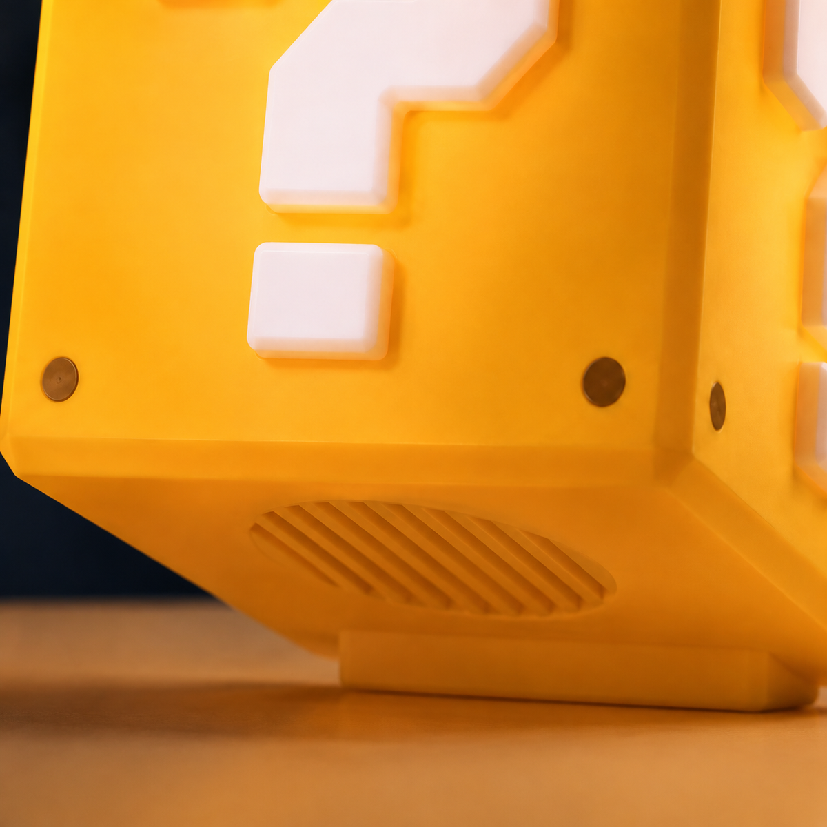 A close-up of a yellow and white 3D-printed block lamp designed to look like a game question block, resting on a wooden surface.