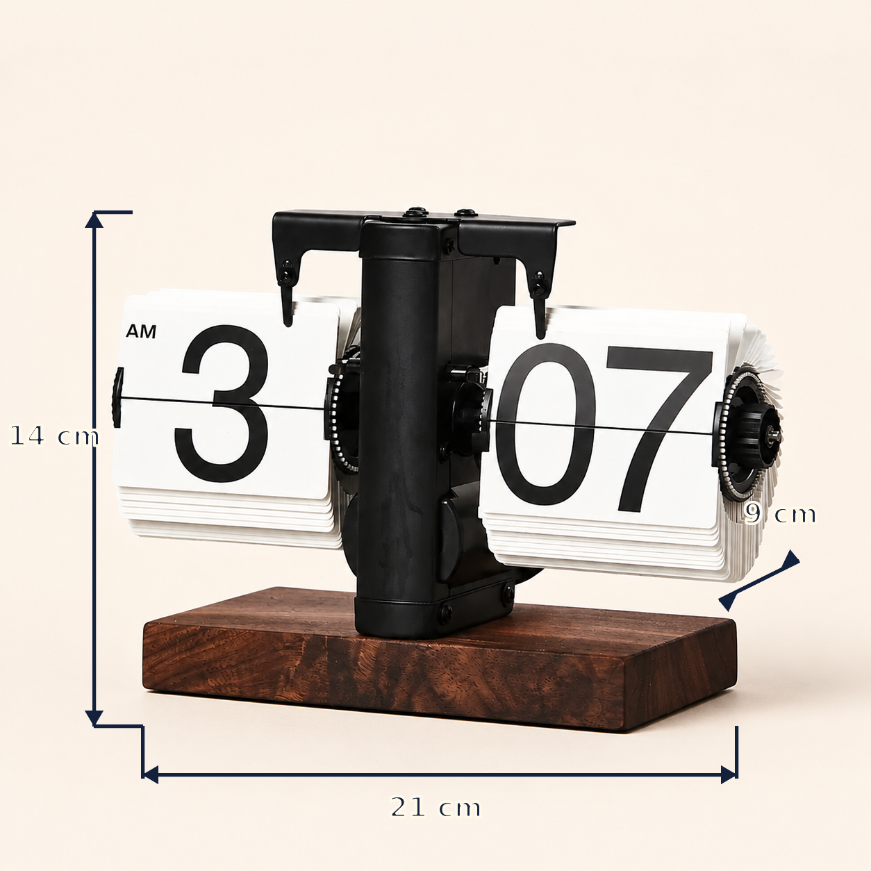 A flip clock tabletop calendar with a dark wood base, black metal mechanism, and white rotating pages showing AM and PM indicators. Blue measurement lines and text annotate dimensions: 14 cm height, 21 cm width, and 9 cm depth, on a light beige background.